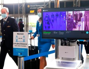 Flight crew walk past thermal cameras that check passengers' body temperatures at Los Angeles International Airport on June 23. As businesses look to reopen, technology firms are offering an array of monitoring systems to try to control the coronavirus.