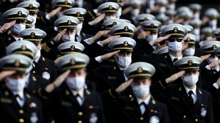 Houston v Navy Midshipmen wearing face masks stand and salute.