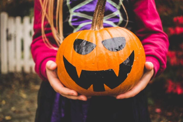 Girl in costume holding a pumpkin