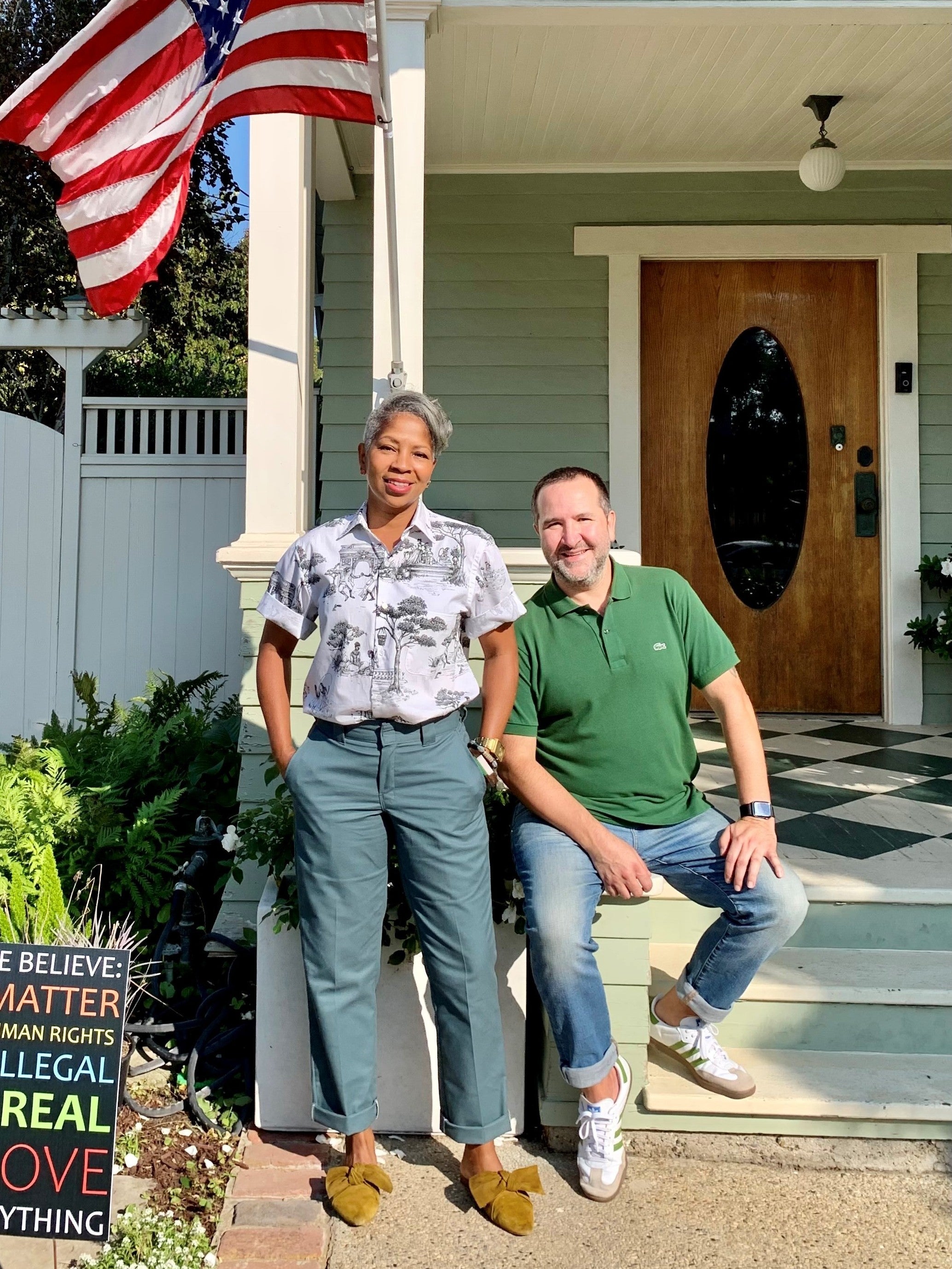 Denise and Kevin Lopez outside their home, alongside an American flag