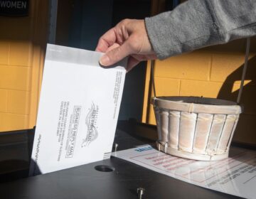 A voter returns their mail ballot