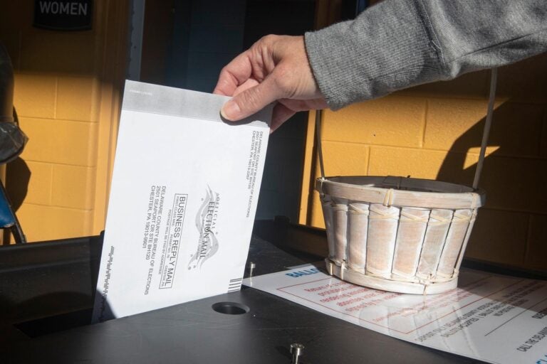 A voter returns their mail ballot
