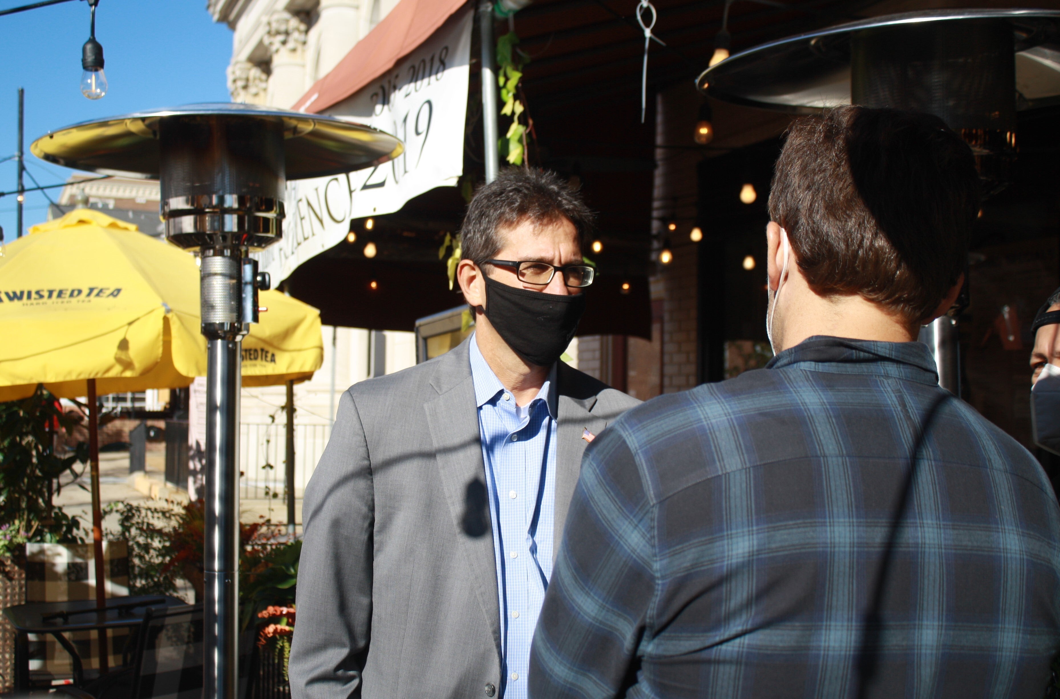 NCCo Executive Matt Meyer talks with Caffé Gelato owner Ryan German under heat lamps outside German's restaurant in downtown Newark