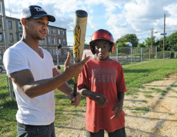 Bryan Morton coaches a child in Camden in 2011, at about the time he founded the North Camden Little League. (April Saul for WHYY)