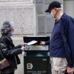 Alice and Len Sayles return their ballots in the drop box outside City Hall