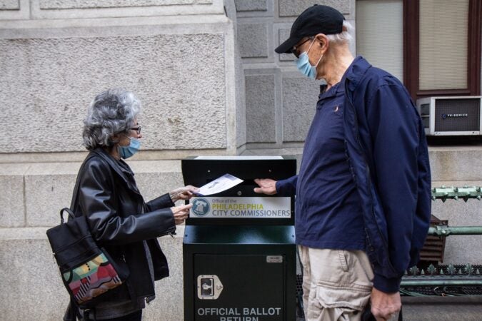 Alice and Len Sayles return their ballots in the drop box outside City Hall