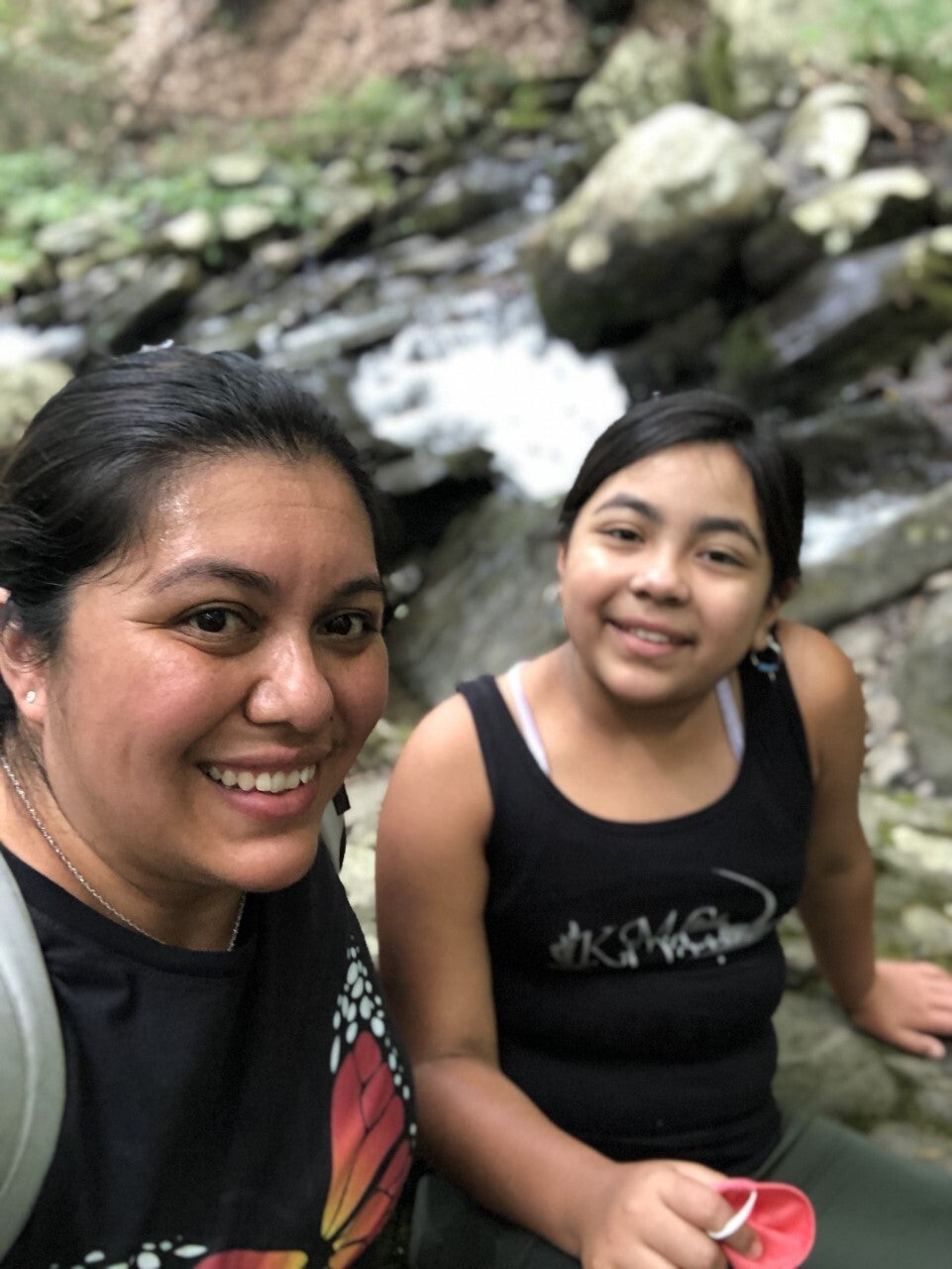 A mother and daughter by a waterfall