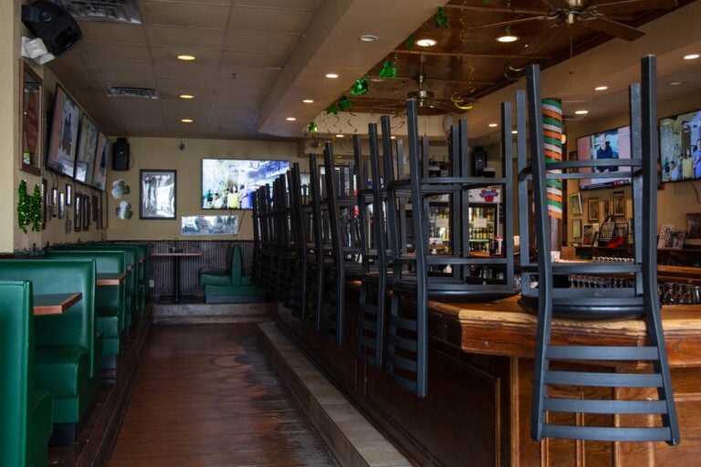 The interior of a restaurant, with stools overturned on tables