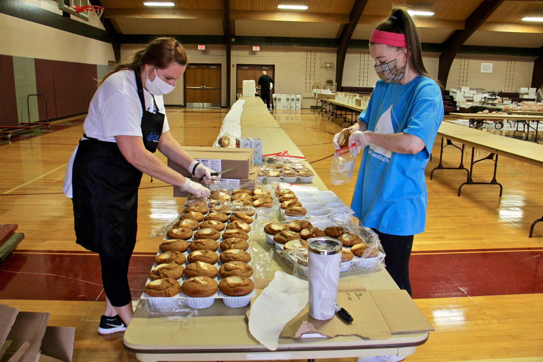 Colleen Fuchs (left) and Natalie Capobianco put together Thanksgliving meals at St. Robert Bellarmine Church