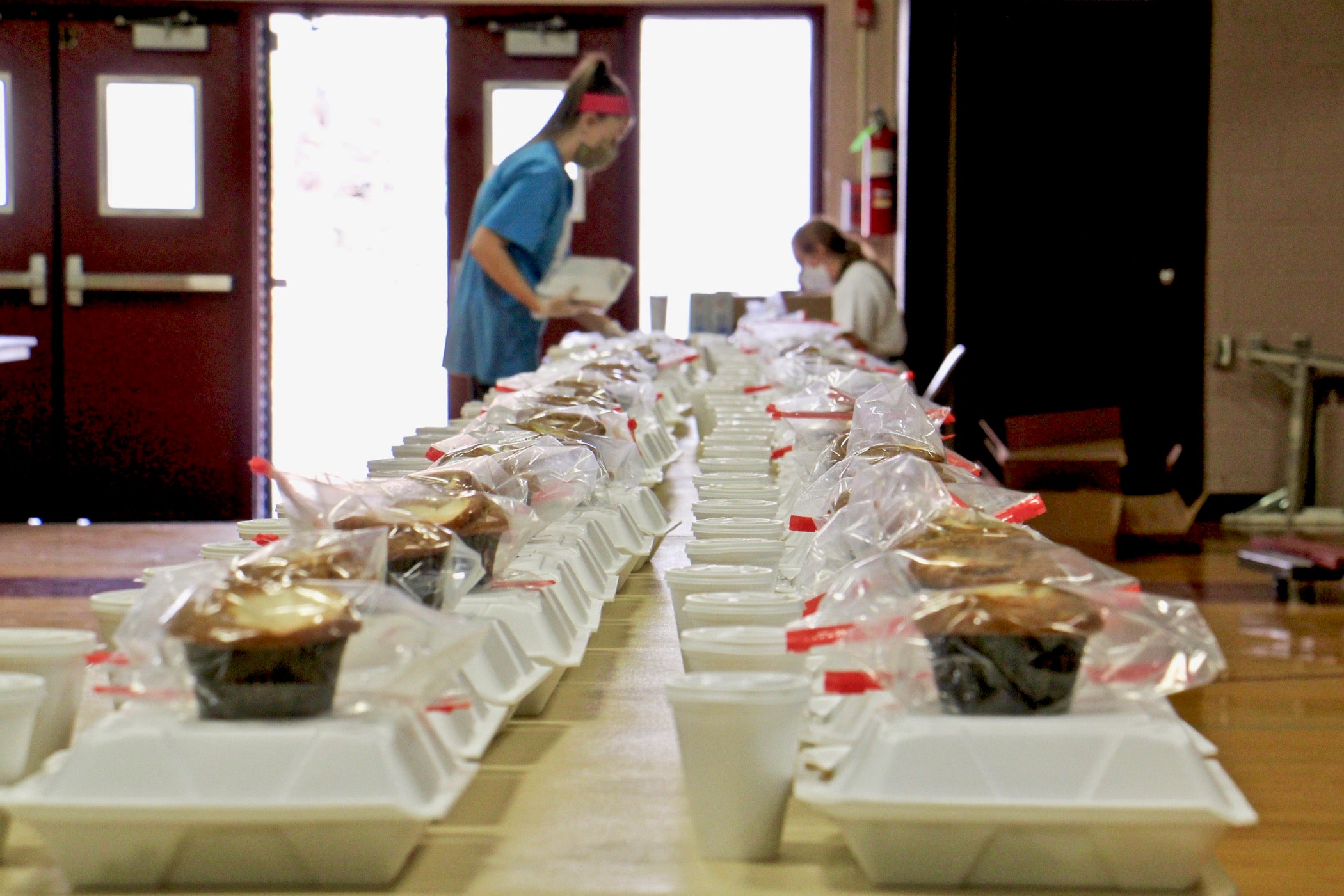 Colleen Fuchs (right) and Natalie Capobianco put together Thanksgiving meals at St. Robert Bellarmine Church