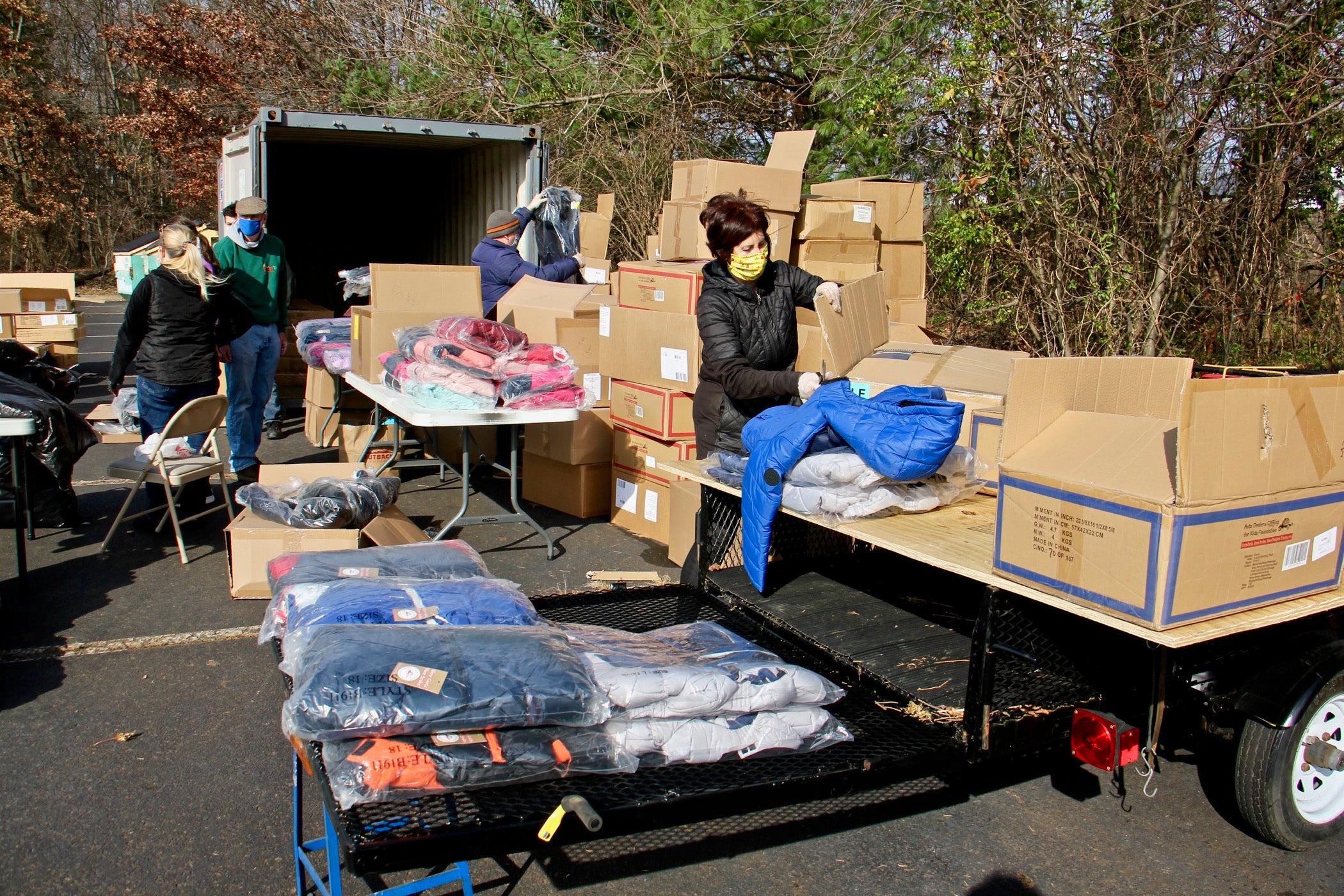 Volunteers unpack winter coats in the parking lot at St. Robert Bellarmine Church