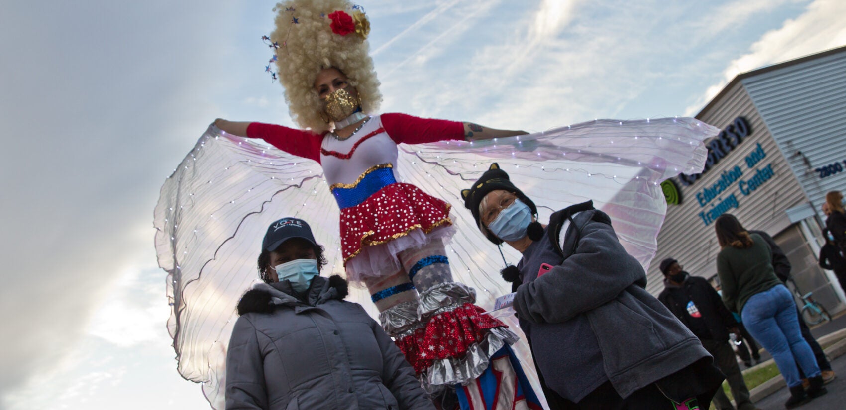 Stilt waker Erin Flannigan (center) entertained voters at Congreso Training Center in Kensington. Poll workers Tara Fisher (left of Flannigan) and Wanda Cordero were grateful.