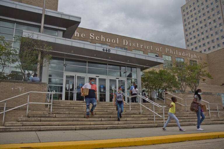 Families stand in line at Philadelphia School District headquarters to pick up Chromebooks ahead of the start of the school year in September 2020. (Kimberly Paynter/WHYY)