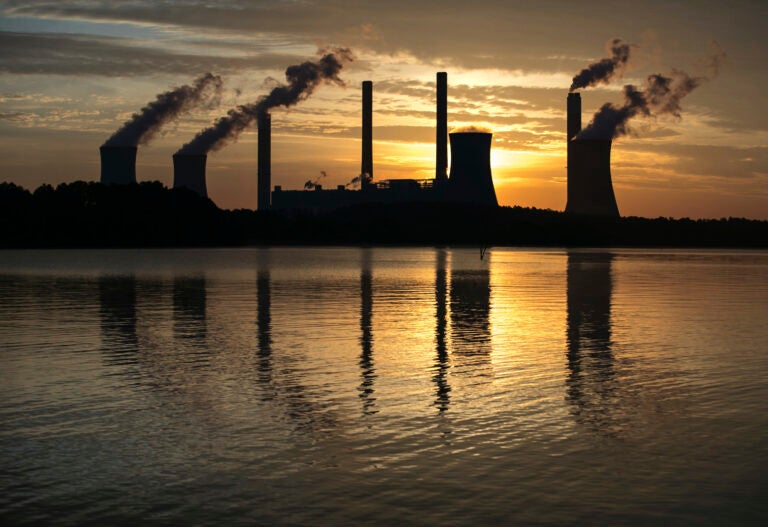 In this June 3, 2017 file photo, the coal-fired Plant Scherer, one of the nation's top carbon dioxide emitters, stands in the distance in Juliette, Ga. (AP Photo/Branden Camp)