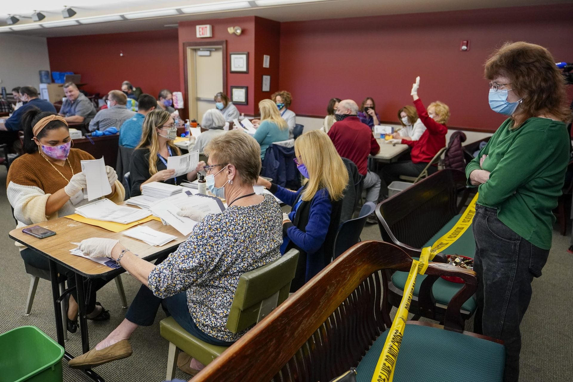 Lynn Muchler-Stash, right, an observer with the Democratic Party of Pennsylvania watches as municipal workers sort and count Luzerne County ballots, Wednesday, Nov. 4, 2020, in Wilkes-Barre, Pa. 