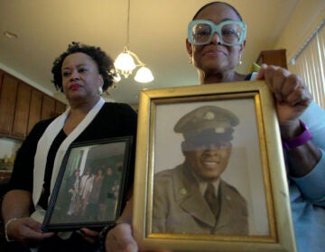 Sisters Barbara Leak-Watkins, right, and Alberta Lynn Fantroy pose with photos of their late father, Alex Leak Jr., at Watkins’ home in Greensboro, N.C., on Wednesday, Nov. 4, 2020. The Army veteran died in July after collapsing from dehydration at his assisted living facility, and the family believe pandemic-related neglect is to blame. (AP Photo/Allen G. Breed)