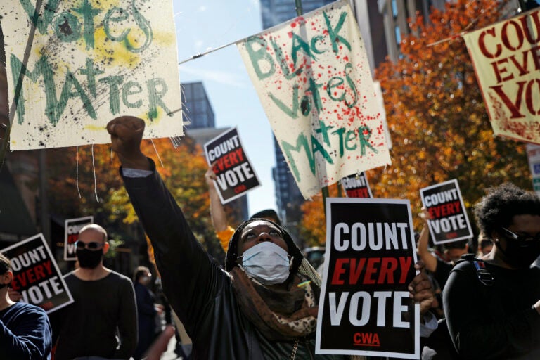 Zhanon Morales, 30, of Philadelphia, raises her fist as demonstrators call for all votes be counted during a rally outside the Pennsylvania Convention Center, Thursday, Nov. 5, 2020, in Philadelphia. (AP Photo/Rebecca Blackwell)