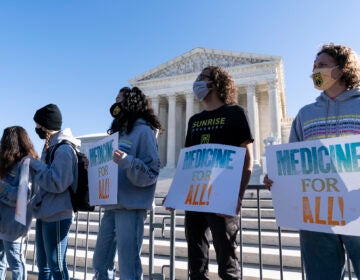 Demonstrators hold signs in front of the U.S. Supreme Court as arguments are heard about the Affordable Care Act Tuesday, Nov. 10, 2020, in Washington. (AP Photo/Alex Brandon)
