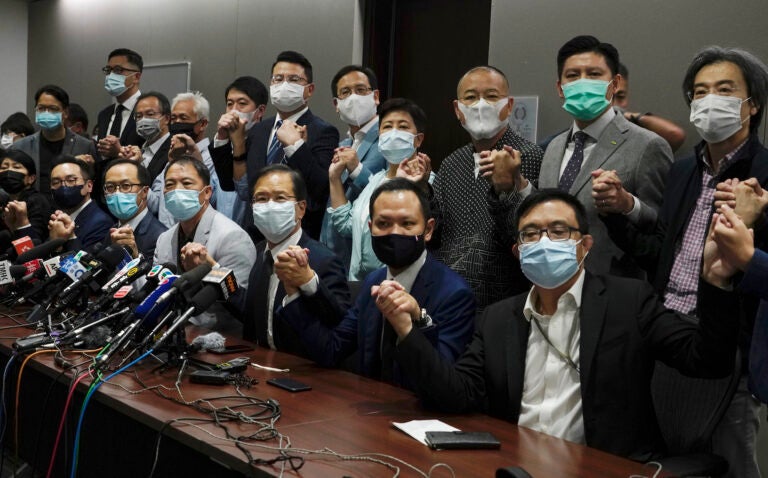 Hong Kong's pro-democracy legislators pose a picture before a press conference at Legislative Council in Hong Kong, Wednesday, Nov. 11, 2020.  Hong Kong’s pro-democracy lawmakers announced that they are resigning en masse following a move by the city’s government to disqualify four pro-democracy legislators. (AP Photo/Vincent Yu)