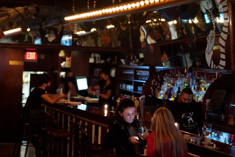 Patrons enjoy food and drink at The Brass Rail in Hoboken, N.J., Wednesday, Nov. 11, 2020. (AP Photo/Seth Wenig)