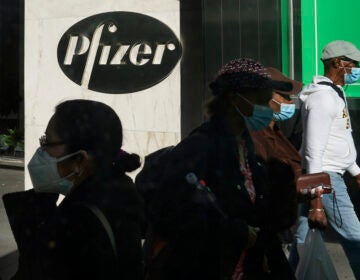 In this Nov. 9, 2020, file photo, pedestrians walk past Pfizer world headquarters in New York.