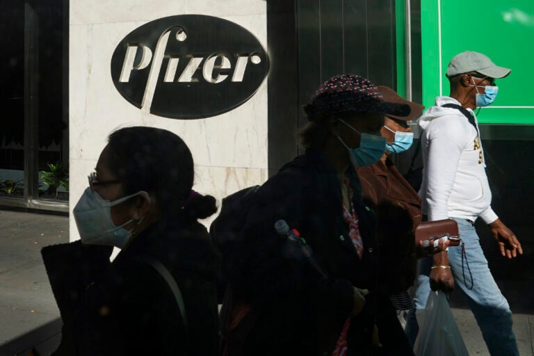 In this Nov. 9, 2020, file photo, pedestrians walk past Pfizer world headquarters in New York.