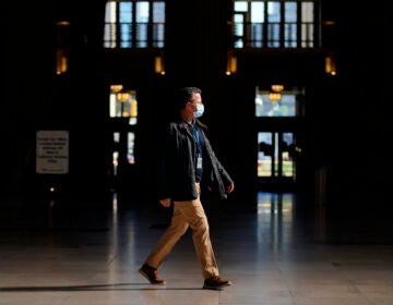 A man walks through the 30th Street Station ahead of the Thanksgiving holiday, Friday, Nov. 20, 2020, in Philadelphia. With the coronavirus surging out of control, the nation's top public health agency pleaded with Americans not to travel for Thanksgiving and not to spend the holiday with people from outside their household. (AP Photo/Matt Slocum)