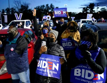 Supporters listen as Democratic presidential candidate former Vice President Joe Biden speaks at a drive-in campaign rally