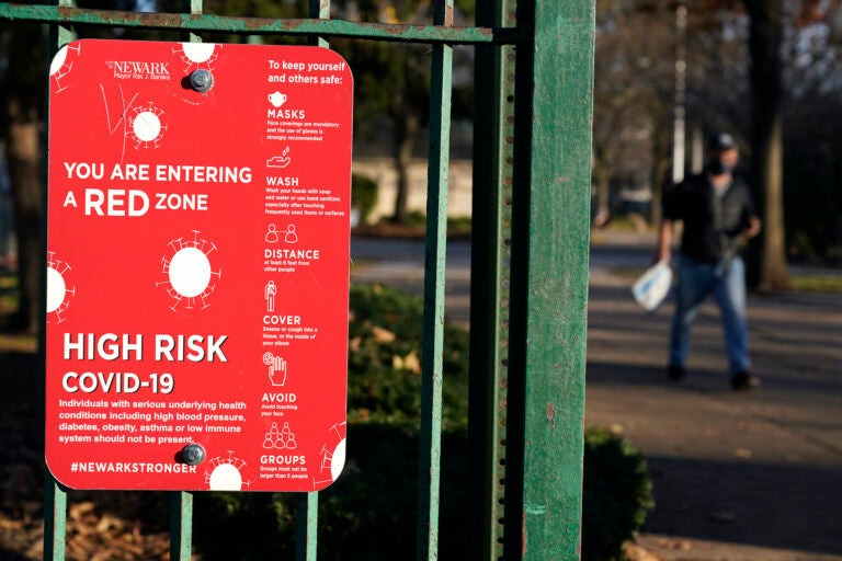 A sign at the entrance to a park warns pedestrians about increased risk for the coronavirus in the Ironbound section of Newark