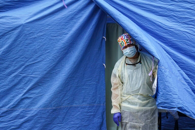 A medical worker operates a testing tent at a COVID-19 mobile testing site