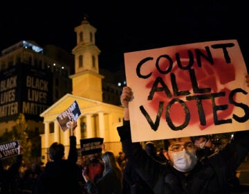 A demonstrator holds up a sign while waiting for election results