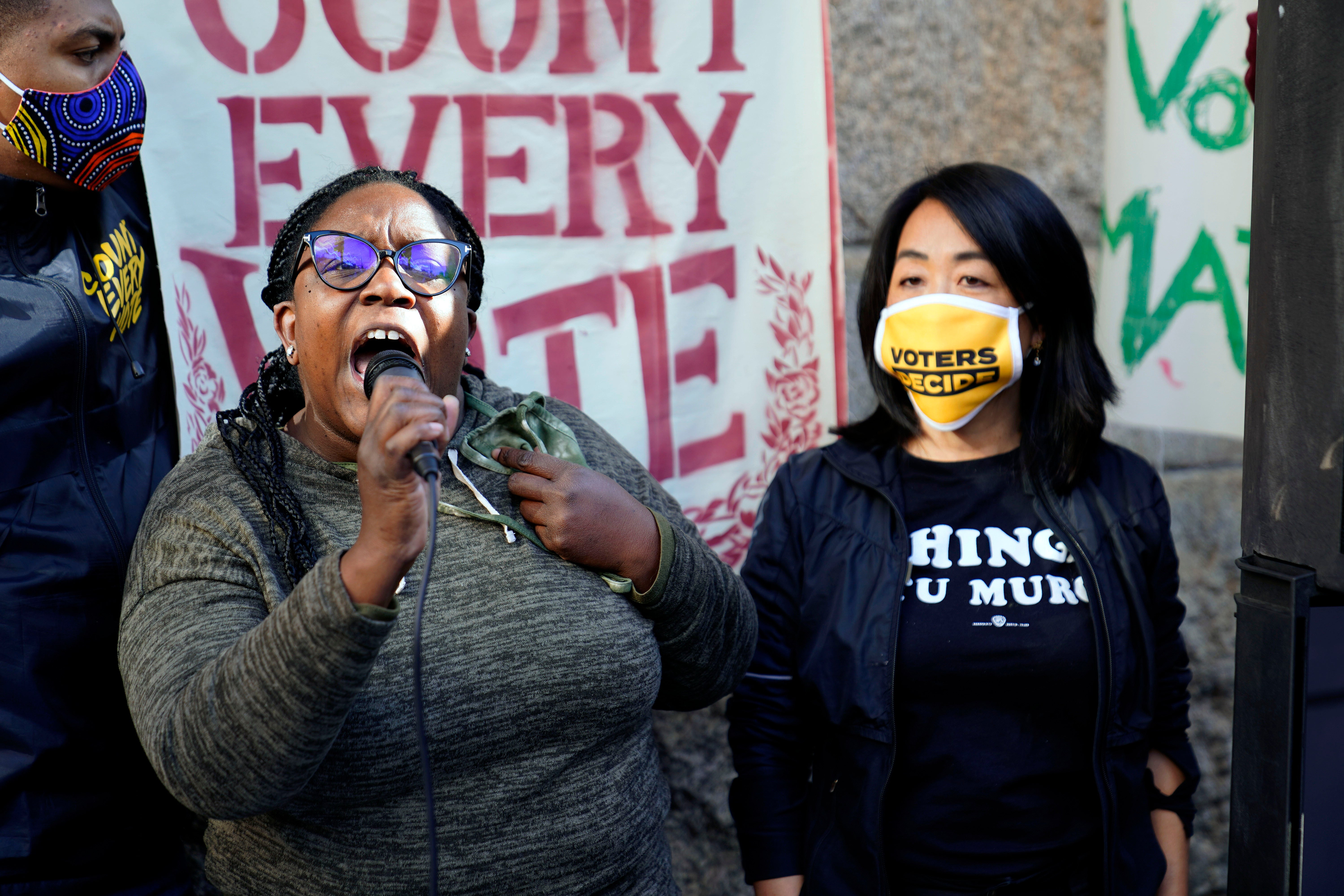 Philadelphia City Councilmembers Kendra Brooks, left, and Helen Gym participate in a demonstration outside the Pennsylvania Convention