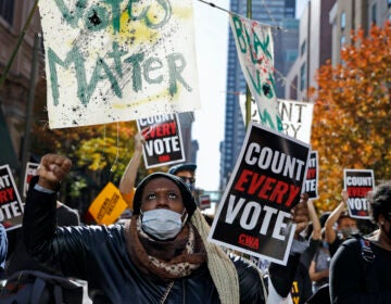 Zhanon Morales, 30, of Philadelphia, raises her fist as demonstrators call for all votes be counted outside the Pennsylvania Convention Center