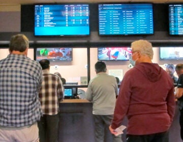 Customers line up to make sports bets at Freehold Raceway in Freehold