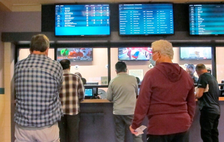Customers line up to make sports bets at Freehold Raceway in Freehold