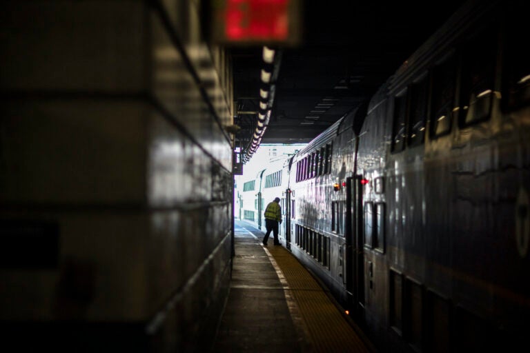 A train employee boards the commuter rail heading to Boston after waiting for passengers.