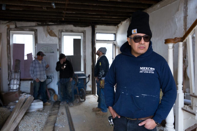 Javier (right) surveys the progress that his employees have made at a job site in South Philadelphia on Jan. 10, 2020. (Photo by Rachel Wisniewski)