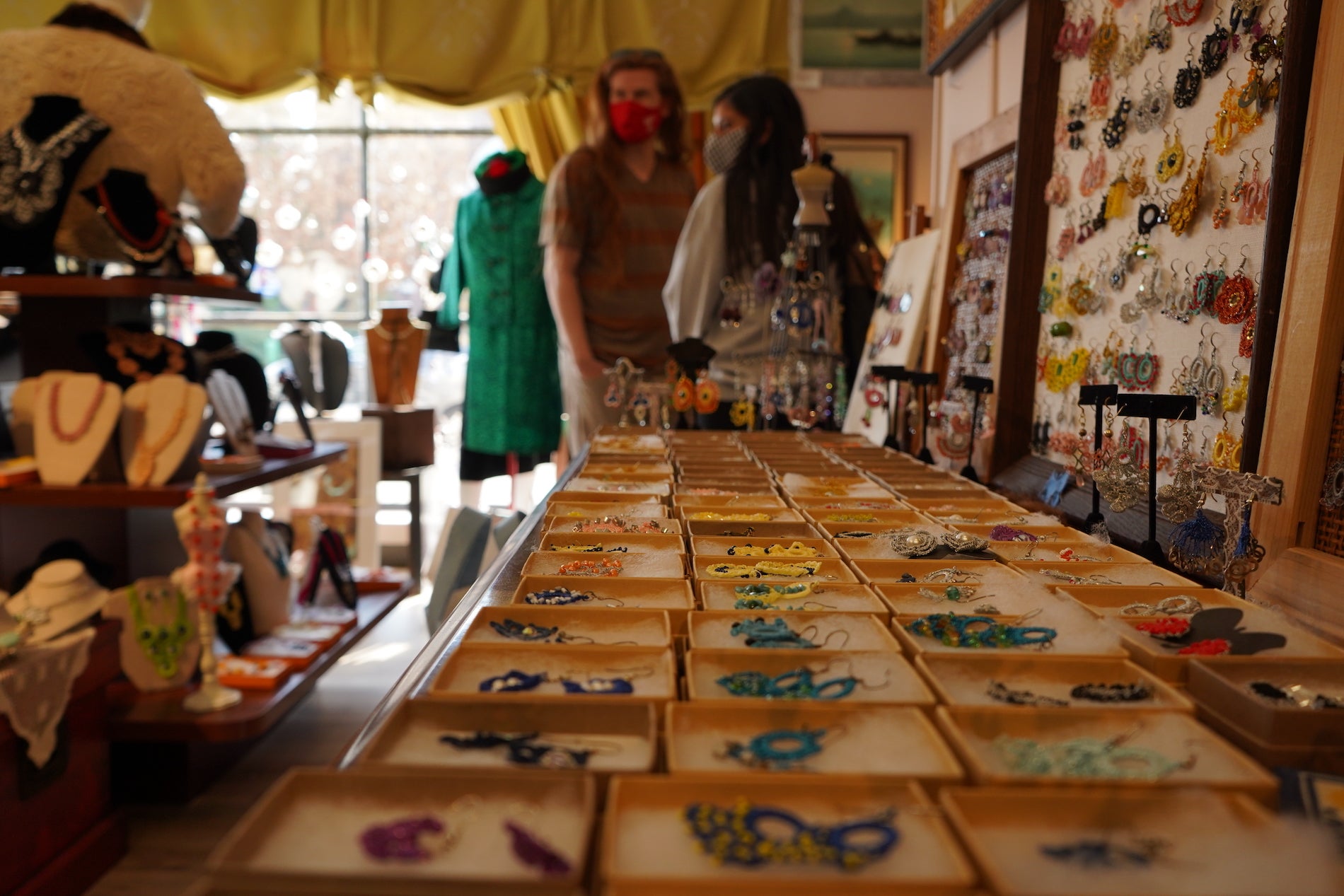 A couple of masked shoppers look at merchandise in Anatolia Art & Craft Studio.