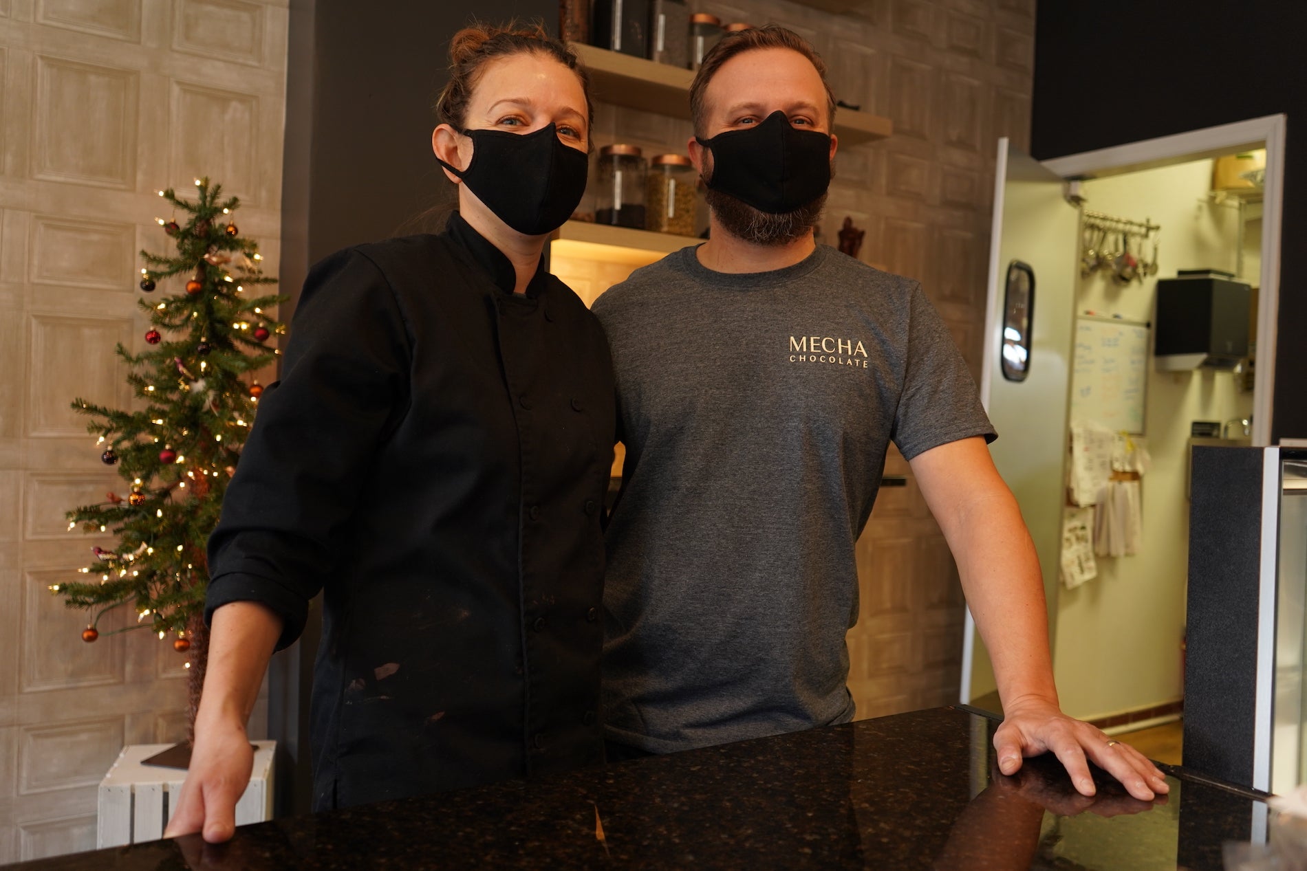 Melissa and Charles Crandley stand behind their countertop in Mecha Chocolate shop. 