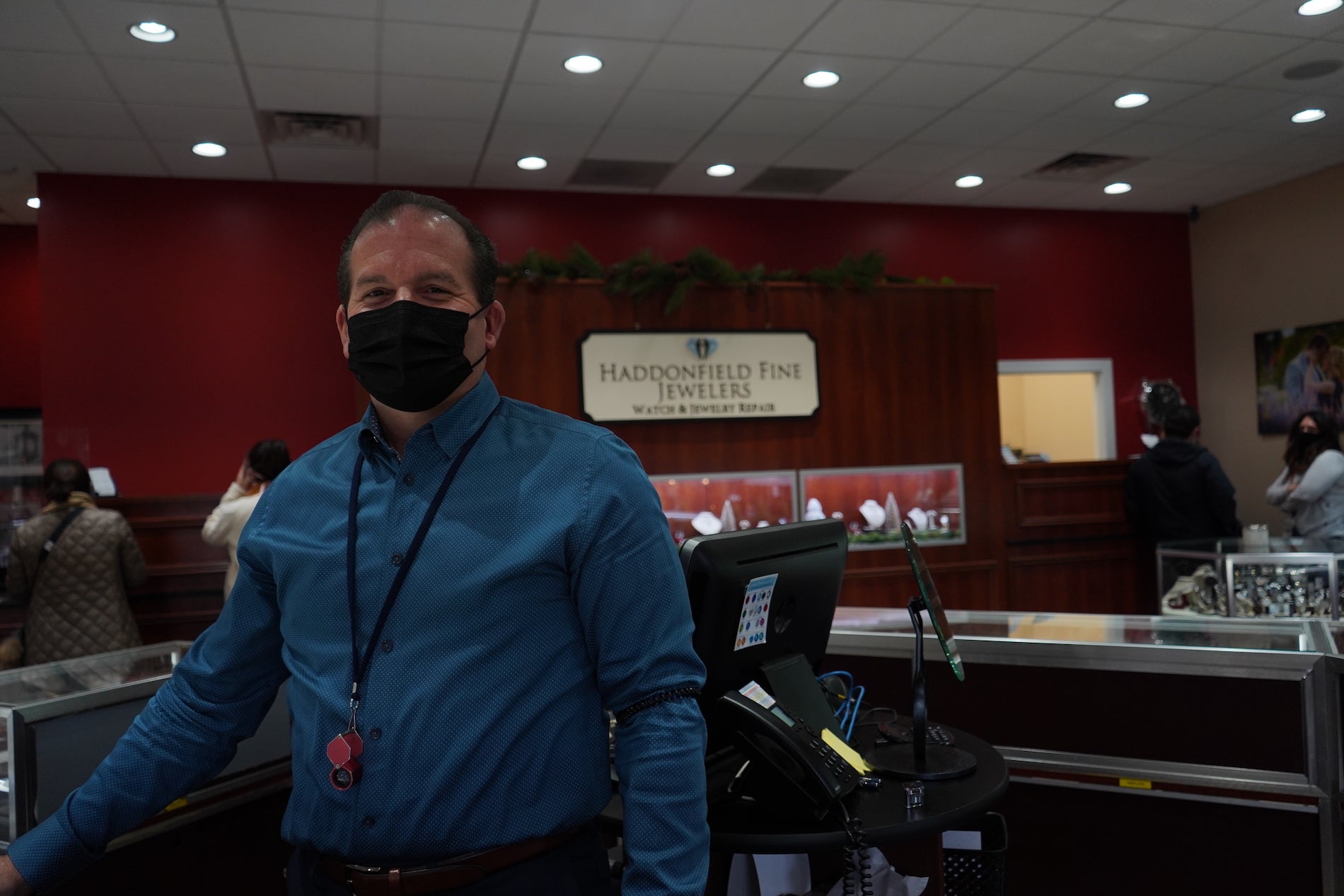 Sam Yampell, chief operating officer of Haddonfield Fine Jewelers, stands behind the display case. 