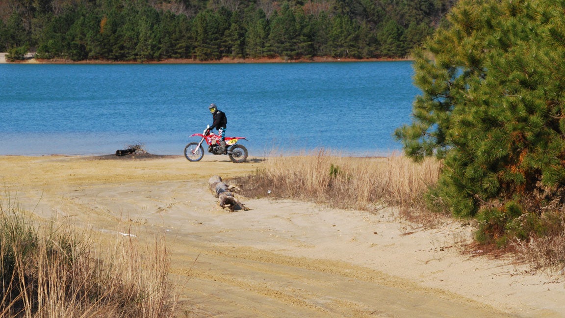 A dirt-bike rider cruises the edge of Cedar Lake.