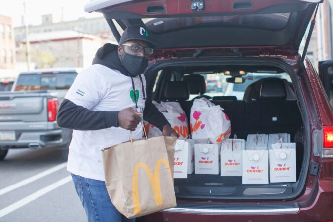 Dessie Hawk of Pull Up Neighbor hands out food to voters as they wait in line up at a polling place in Northern Liberties, Philadelphia in the midst of the Coronavirus pandemic to vote in person, Tuesday, November 3, 2020 in Philadelphia, PA. Pull Up Neighbor is handing out food and providing entrainment to voters at 20 different polling locations in Philadelphia.