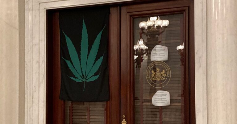 A marijuana leaf flag hangs on the door of Lt. Gov. John Fetterman's office on Sept. 21, 2020. (Sam Dunklau / WITF)