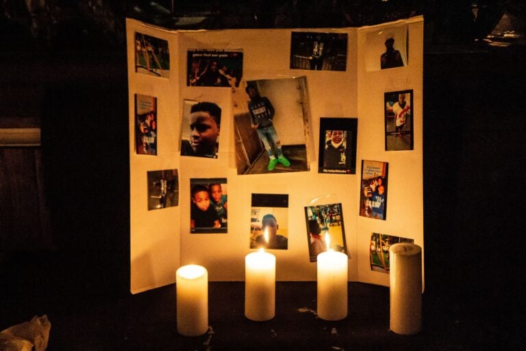 Photos of 12 year-old Sadeek Clark-Harrison and candles honor his life on his porch in Frankford. (Kimberly Paynter/WHYY)