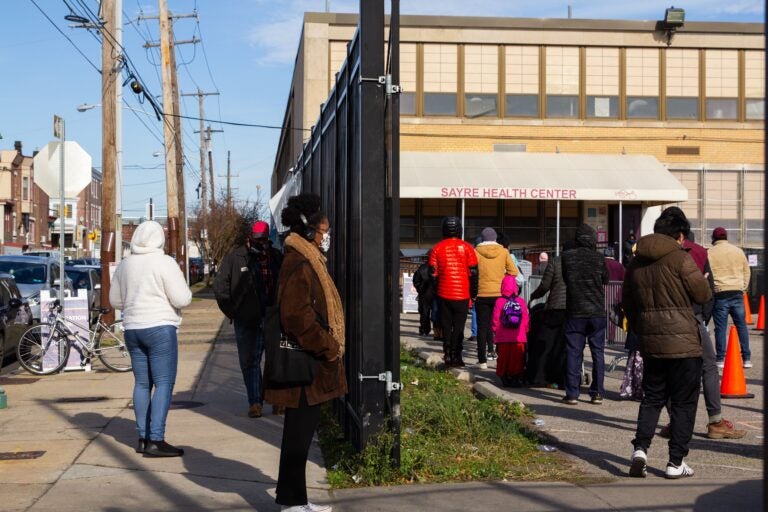 People stand in line outside Sayre Health Center for COVID testing a week before Thanksgiving in West Philadelphia. (Kimberly Paynter/WHYY)