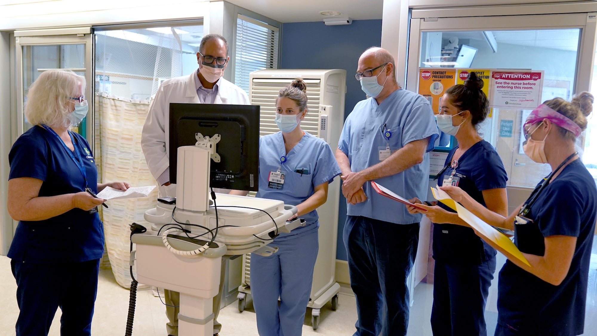 Health care workers complete rounds in the MICU.