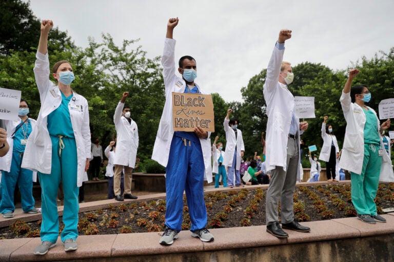 Healthcare professionals gather outside Barnes-Jewish Hospital in St. Louis to demonstrate in support of the Black Lives Matter movement on June 5. The demonstration, called 'White Coats for Black Lives,' was organized to show solidarity with those protesting the death of George Floyd after being restrained by Minneapolis police officers on May 25.
(Jeff Roberson/AP)