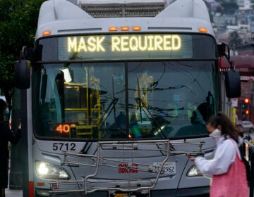 A sign on a bus advises that passengers are required to wear masks. (Jeff Chiu/AP)