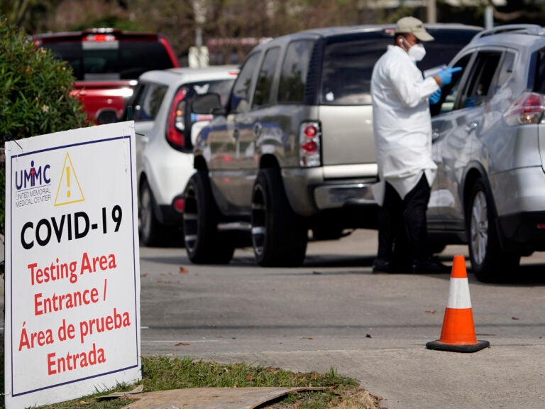 A healthcare worker processes people in line at a United Memorial Medical Center COVID-19 testing site on Nov. 19, in Houston. Texas is rushing thousands of additional medical staff to overworked hospitals as the number of hospitalized COVID-19 patients increases. (David J. Phillip/AP)