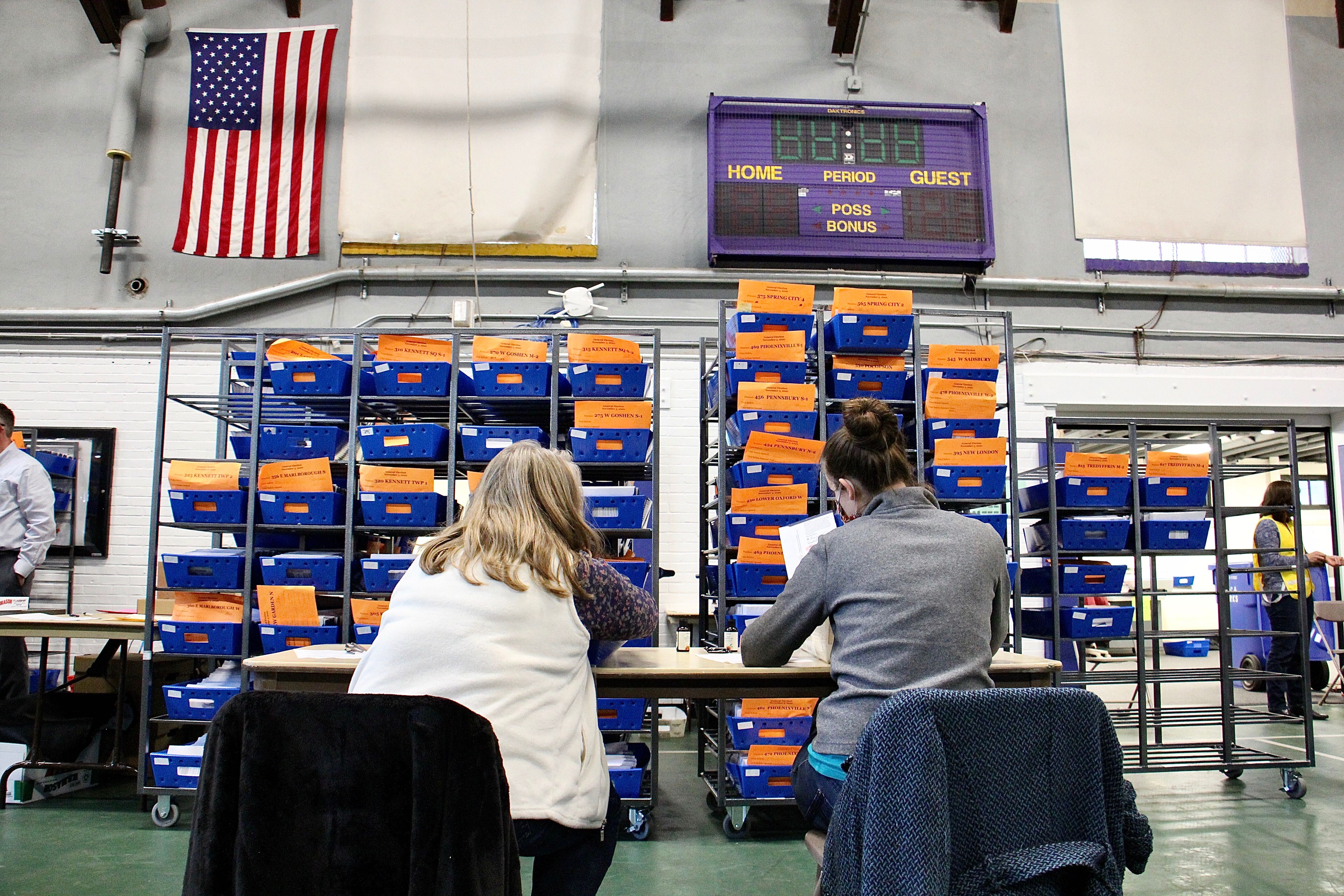 Chester Country election workers check ballots one last time before sending them to be scanned and counted in the West Chester University gym.